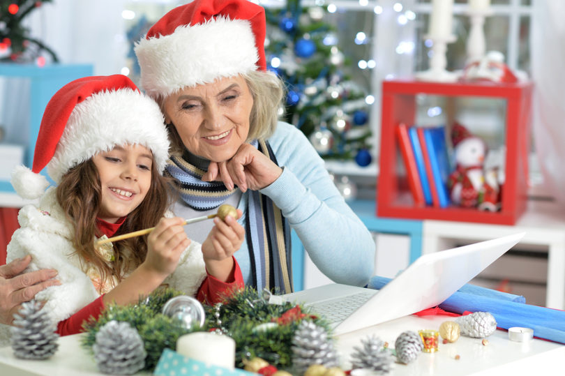 Portrait of grandmother and her granddaughter preparing for Christmas at home